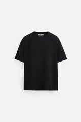 Camiseta negra relaxed fit confeccionada en tejido de algodón compacto con estructura piqué, cuello redondo y manga corta.