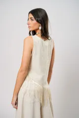 Blusa beige de lino bordado, sin mangas y con terminación en flecos.