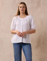 Blusa blanca labrada con cuello a la base, abertura central con botones y mangas cortas. Marca Sabrina Lauren.