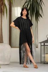 Vestido negro de algodón con corte recto, cuello redondo, mangas cortas, tachas plateadas en el frente y flecos largos en el ruedo.