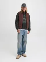 Buzo de manga larga y cuello redondo, color negro, con fit holgado. Presenta un estampado frontal en tonos verde menta y blanco con texto que incluye "Originals Studio", "Daily Basics", "International", "connecting CREATIVITY ACROSS DISTANCES" y "est. 90".