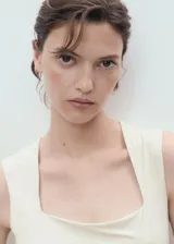 Top sin mangas color crema, de tejido elástico y diseño entallado, con escote cuadrado y tirantes anchos.