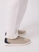 Pantalón de vestir color beige, de corte recto, con bolsillos laterales y traseros. Se ajusta a la cintura con botón y cierre.