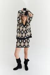 Sweater de lana color beige con diseño geométrico de rombos en tonos beige y blanco, cuello en V y corte holgado.