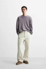 Jersey de hombre color lila, tejido en hilatura de algodón con textura. Tiene cuello redondo, manga larga y acabados en rib con detalle de vuelta.