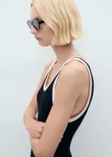 Vestido midi negro de tejido de punto fino, sin mangas, con cuello redondo, tirantes anchos y ribete en contraste blanco en cuello y sisas.