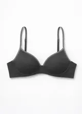 Soutien de microfibra negro, sin costura, con copa preformada y aro. Los breteles son ajustables y presentan un patrón de puntos blancos.