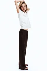 Pantalón marrón de corte holgado en tejido liviano de mezcla de lino. Modelo de tiro alto con cintura elástica y cordón para ajustar fino, bolsillos laterales discretos y piernas rectas.