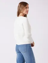 Cardigan tejido color fucsia, con escote a la base y abertura central con botones metálicos dorados. Presenta bolsillos simulados en la parte delantera y terminación desflecada en la abertura y los bolsillos.