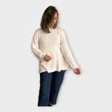Sweater tejido color crudo, con escote redondo y hebra en relieve con brillo.