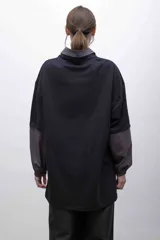 Remerón negro oversize con cuello camisero gris, mangas largas grises con puños elásticos, bolsillo con tapa en el pecho y logo bordado.