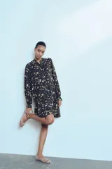 Vestido corto de viscosa con estampado floral, corte holgado, cuello mao, botones frontales, mangas globo largas con abertura y botón en los puños, y costura fruncida en la falda para un efecto evasé.