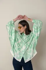 Camisa italiana de satén de seda estampada en blanco y negro, con cuello camisero y mangas murciélago.