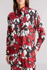 Camisa de satén calado estampado con diseño floral en rojo, blanco y negro. Tiene calce regular, mangas largas y cartera delantera con botones metálicos a tono.