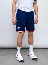 Bermuda deportiva azul con cintura elastizada ajustable con cordón, bolsillos laterales y escudo del Club Nacional de Football estampado en la pierna izquierda.