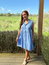 Vestido camisero azul sin mangas de lino italiano, con botones de nácar y corte a la rodilla.