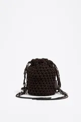 Bolso marrón tipo bucket, tejido con cordones gruesos, con asa corta y cierre ajustable con cordón. Incluye etiqueta logotipada BIMBA Y LOLA y charms metálicos plateados.