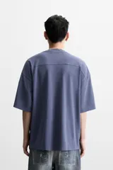 Camiseta azul de corte holgado, cuello redondo y manga corta. Tiene un efecto lavado que le da una apariencia única.