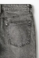Pantalón de jean gris con efecto lavado, corte regular tapered, tiro medio, cinco bolsillos y cierre con botón y cremallera.