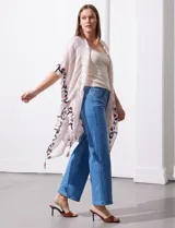 Kimono tejido con estampado abstracto en tonos beige, blanco y negro. Tiene mangas amplias estilo japonés y terminación de ruedo con borlas.