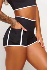 Short deportivo negro de cintura alta con ribete blanco y bolsillos laterales. Ideal para actividades al aire libre, cuenta con protección UV50+.