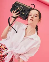 Bandolera color beige con textura símil reptil, cierre con broche metálico dorado y correa larga regulable.