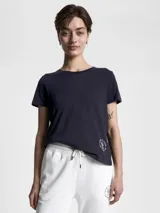 Remera azul marino de cuello redondo y manga corta, confeccionada en algodón. Presenta un logo de Tommy Hilfiger en el lateral inferior.