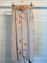 Pantalón palazzo verde claro con estampado de flores rosas, cintura elástica y lazo ajustable.