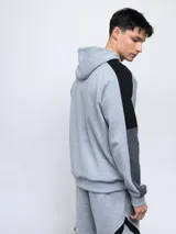 Buzo canguro gris con capucha, mangas ranglán celestes y detalles en blanco. Logo de Umbro bordado en el pecho.