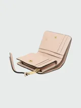 Billetera mini compacta Marc Jacobs color beige con logo dorado en el frente y correa de muñeca rosa.