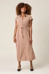 Vestido camisero color beige con cuello, botones frontales, mangas cortas y lazo ajustable en la cintura.