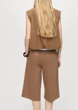 Short de algodón color marrón, con tiro medio, diseño recto, pinzas delanteras y cinturón ajustable. Presenta bolsillos laterales y dos bolsillos de ribete en la parte posterior.