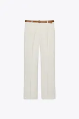 Pantalón negro de tiro alto con pernera recta, bolsillos frontales y falsos bolsillos con solapa en la espalda. Incluye cinturón marrón de cuero sintético.