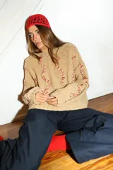 Sweater tejido a mano con lana merino color negro y bordado con lana color crudo. Es corto, a la cintura y de cuello alto.