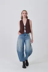 Chaleco sin mangas color marrón oscuro, de corte ajustado al cuerpo, con escote en V y cierre frontal mediante lazos anudados con detalles de cuentas oscuras.