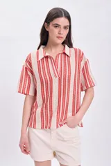 Top de punto crochet color rojo con cuello polo y cierre parcial con botones.