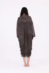 Vestido camisero largo midi de silueta envolvente, confeccionado en tejido liviano y fluido, color gris oscuro con efecto desgastado. Presenta cierre frontal con botones ocultos, cuello clásico, mangas largas con puño y frunces centrales que aportan volumen y movimiento.