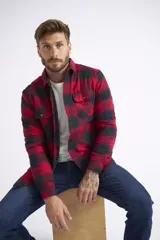 Sobrecamisa de viyela para hombre con estampado de cuadros en rojo y negro. Presenta cierre frontal con botones, bolsillos en el pecho con solapa y botón, y un interior capitoneado para mayor abrigo. Cuenta con un logo en grifa de cuero.