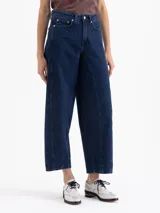 Jeans de denim azul oscuro, tiro alto, con calce slouchy y pierna ancha y corta. Presenta costuras curvas distintivas en el frente que definen la forma de la pierna.