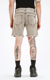 Bermuda de denim gris con efecto lavado, cinco bolsillos, calce regular y ruedo desflecado.