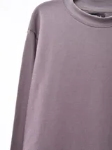 Buzo negro de corte holgado, cuello redondo y mangas largas.