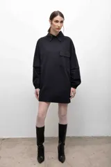 Remerón negro con cuello camisero gris, mangas largas grises con puños elásticos y bolsillo con solapa en el pecho.