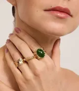 Set de tres anillos dorados con diferentes diseños y texturas. Uno de los anillos tiene una piedra verde ovalada.
