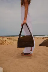 Bolso de hombro marrón de cuero con diseño de paneles rectangulares cosidos.