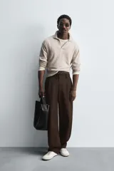 Sweater tipo polo color beige, de punto con mezcla de algodón y lana, corte regular fit, cuello solapa con abertura en V y mangas largas con terminaciones en rib.