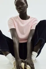 Remera rosa de punto fino con cuello redondo y mangas cortas.