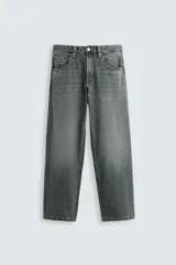 Pantalón de jean celeste con efecto lavado, corte amplio tipo baggy, cinco bolsillos y cierre frontal con cremallera y botón.