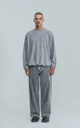 Sweater gris jaspeado de manga larga y cuello redondo, con elástico ajustable en el ruedo inferior.