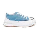 Championes deportivos de tela color celeste con detalles en blanco, cordones blancos y suela gruesa blanca con base marrón.