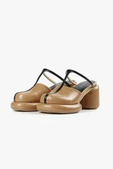 Mule color caramelo con plataforma y taco cilíndrico, tira superior negra y puntera cuadrada.